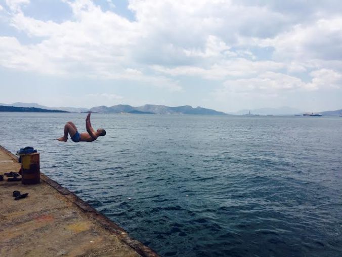 A refugee at Skaramagas camp swims in the food-littered industrial waters of Piraeus. Photo by Hayley Roth