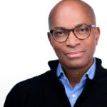 Ron Allen in front of a while background.